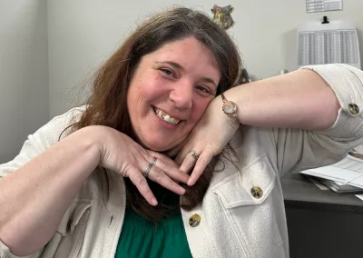 woman smiling with hands under her chin