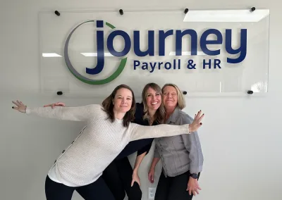 group of people in front of Journey Payroll sign in an office