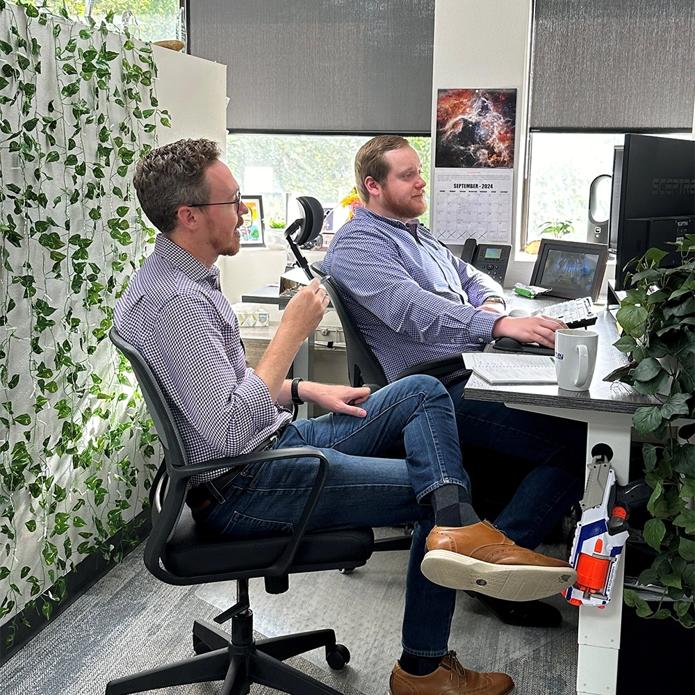 two people working together, on computers