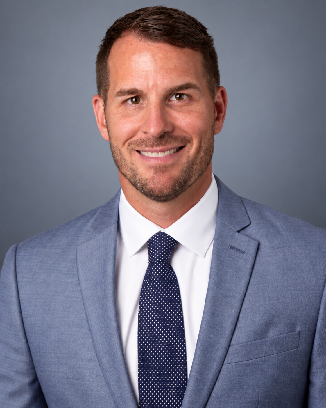 man smiling, wearing a suit